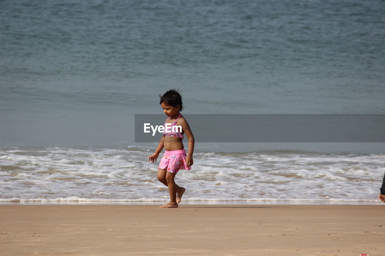 Full length of girl walking on shore at beach