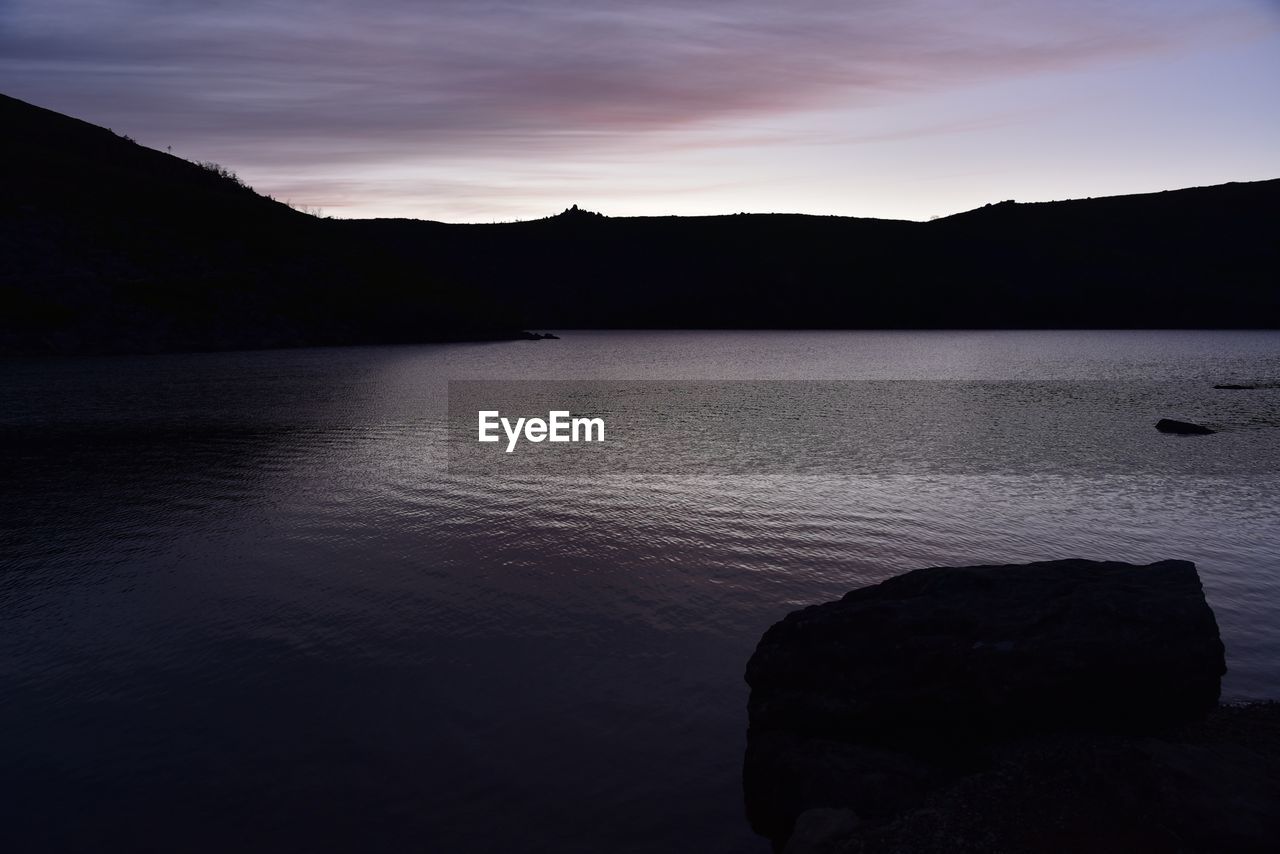 SCENIC VIEW OF SEA AND SILHOUETTE MOUNTAINS AGAINST SKY