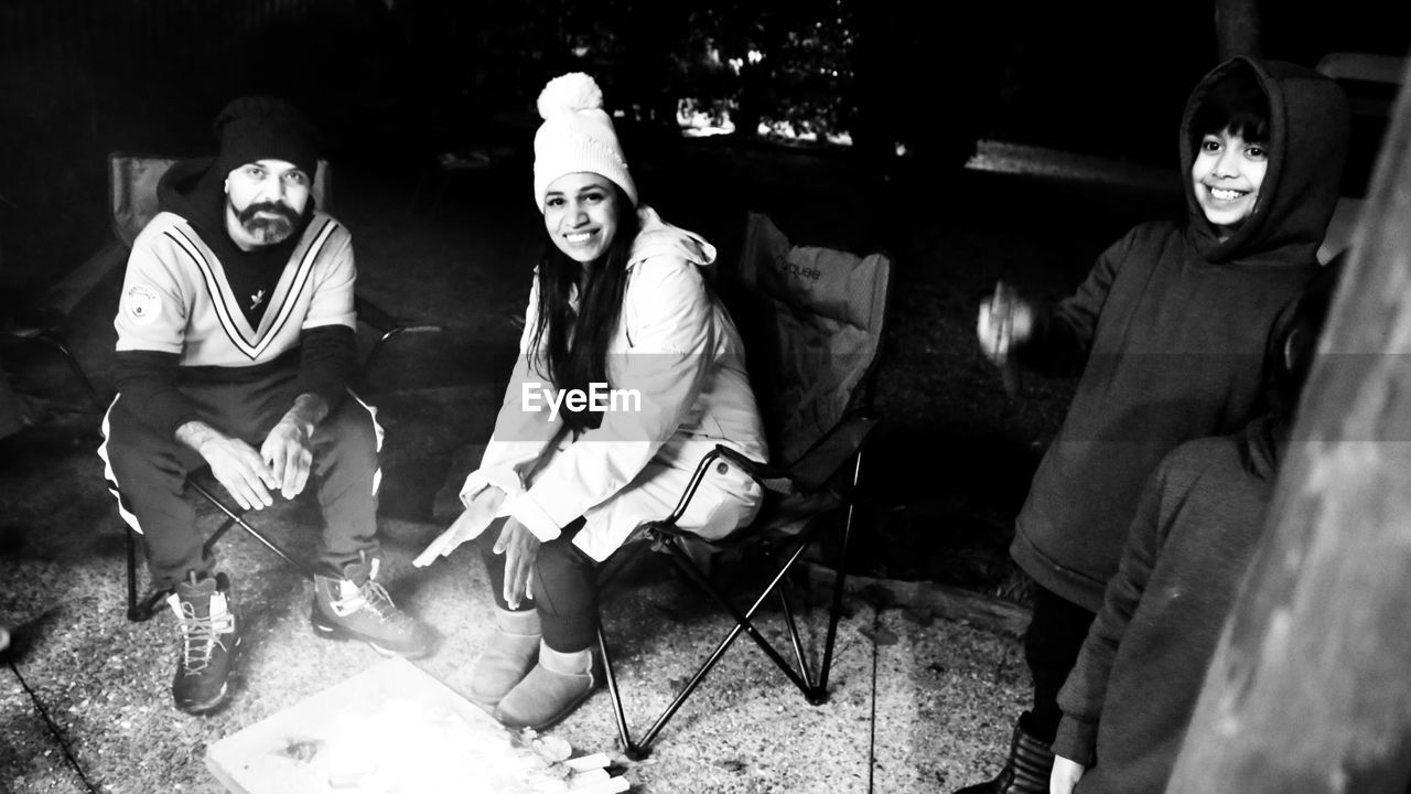 black and white, monochrome photography, monochrome, adult, men, group of people, sitting, arts culture and entertainment, black, smiling, small group of people, night, darkness