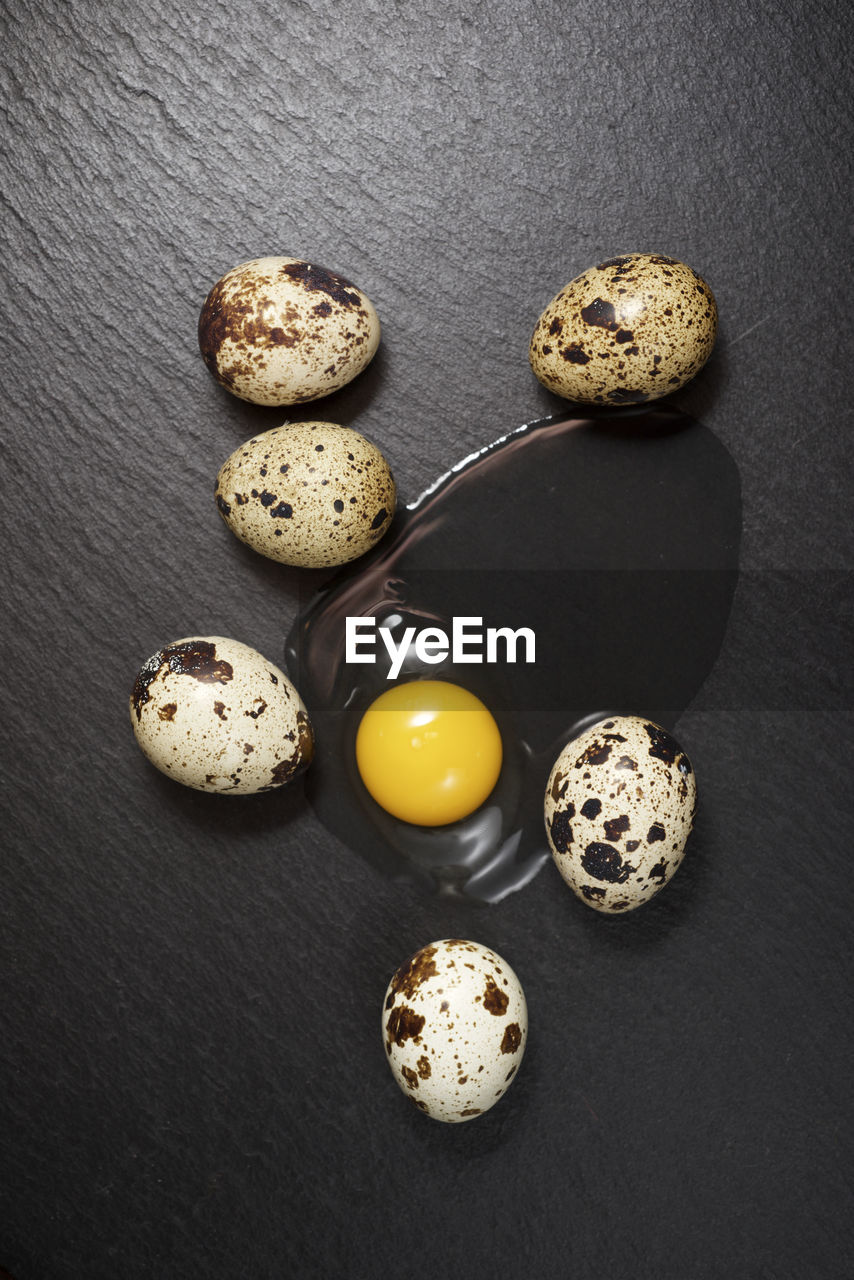 Quail eggs on a black table.