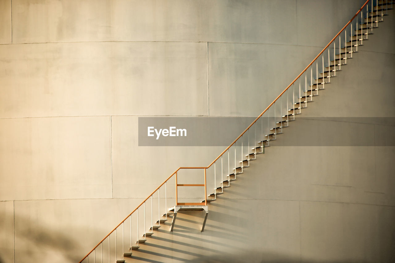 Low angle view of staircase against storage tank