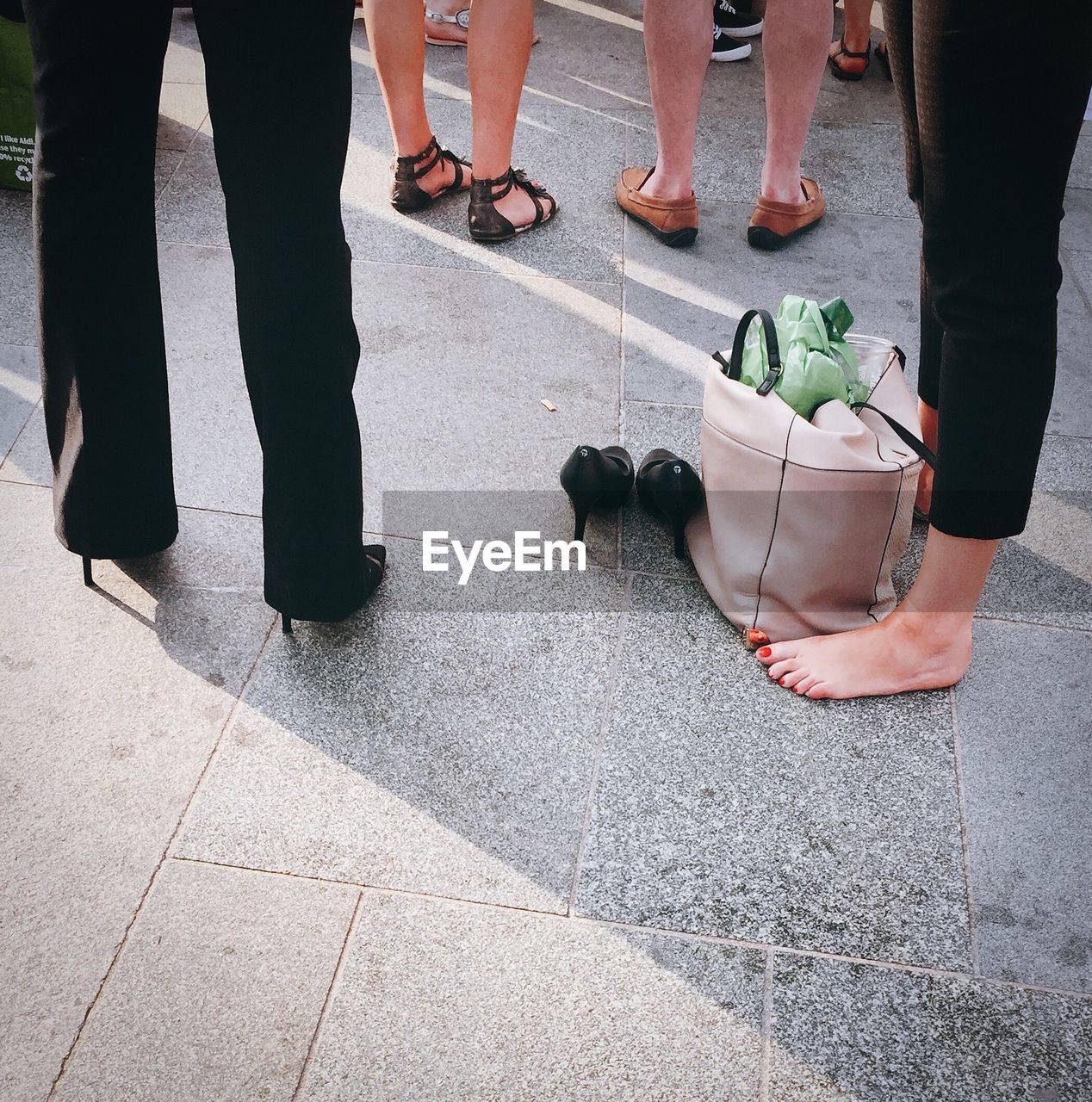 Low section of people standing on sidewalk