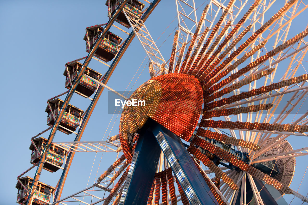 Low angle view of illuminated ferris wheel against clear sky