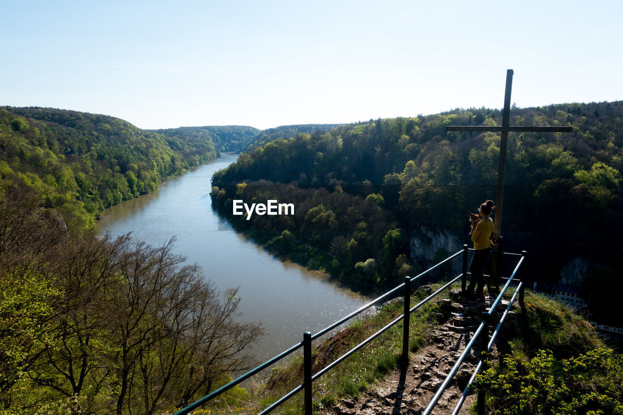 High angle view of woman standing on bridge over river at donaudurchbruch bei weltenburg