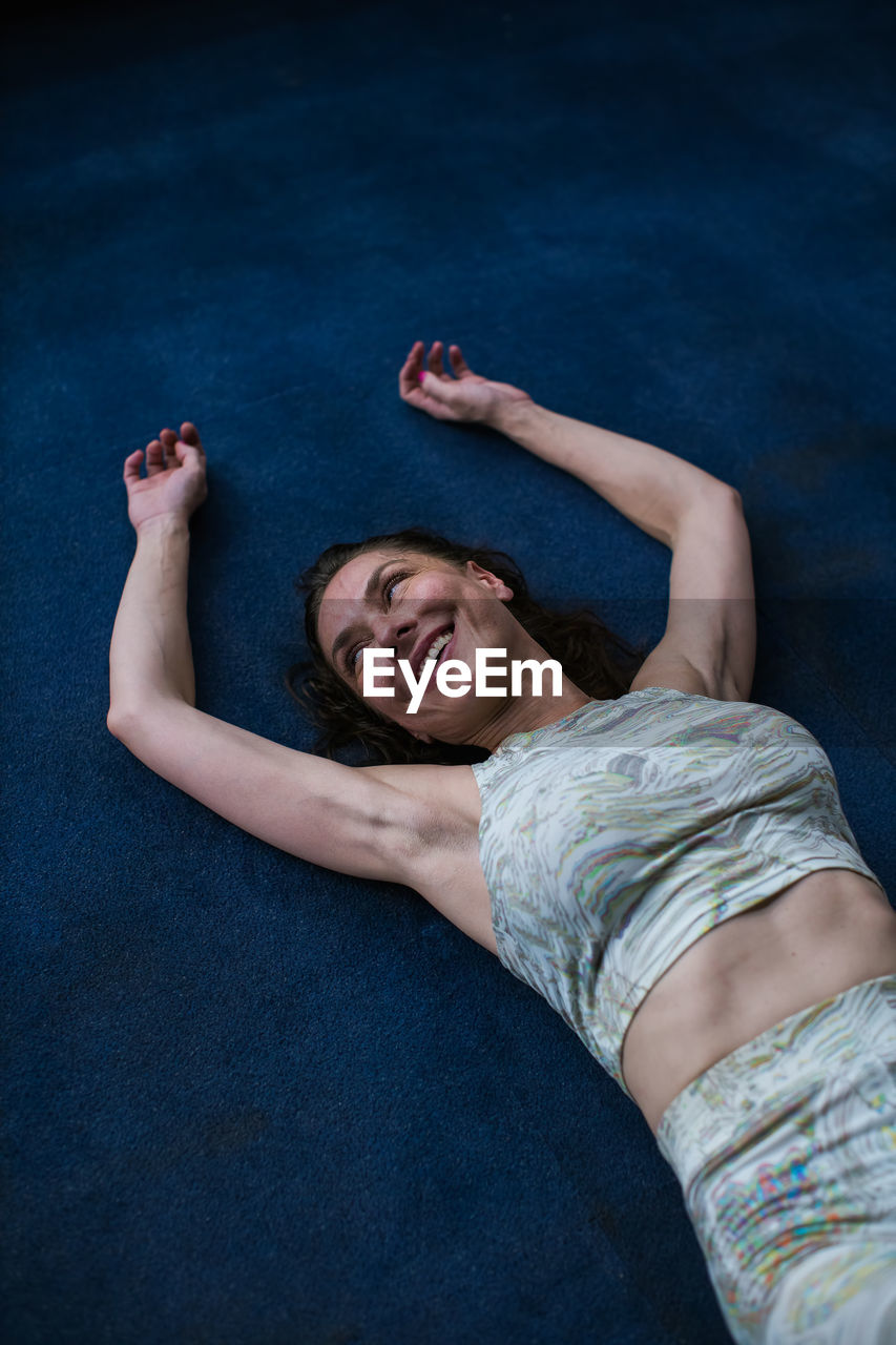 Woman smiling while laying down on floor