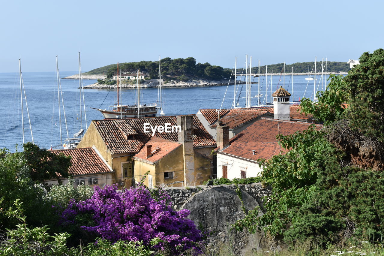 Scenic view of sea by buildings against clear sky