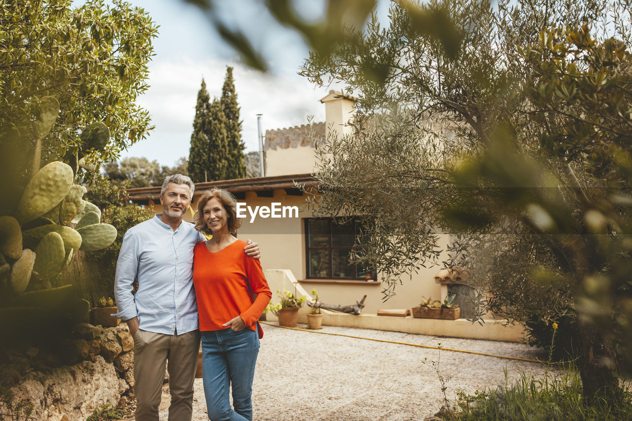 Happy mature woman standing with man in back yard