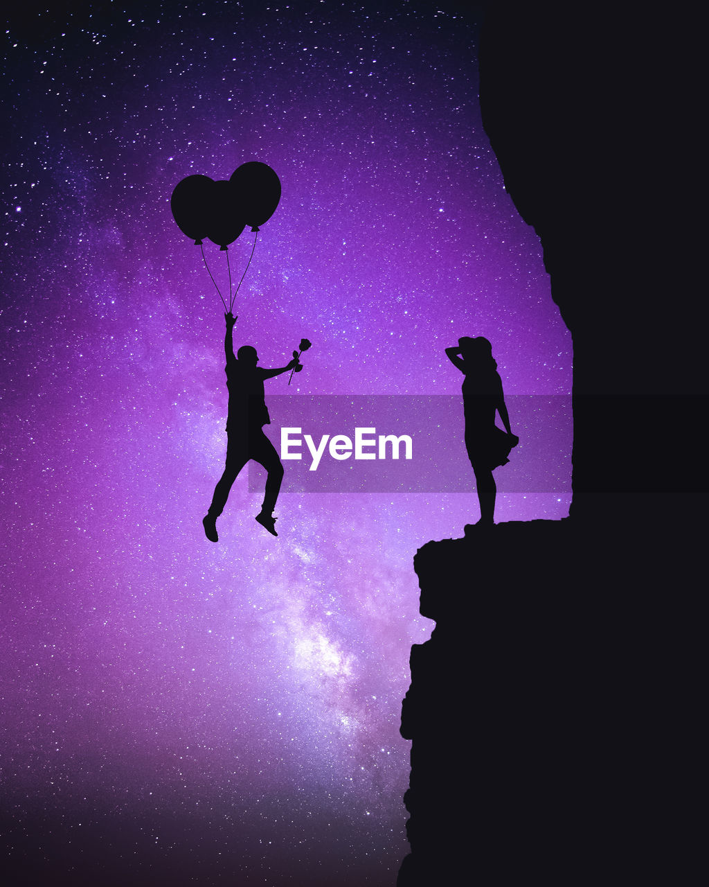 Low angle view of silhouette man holding rose and balloons by woman on cliff against purple sky