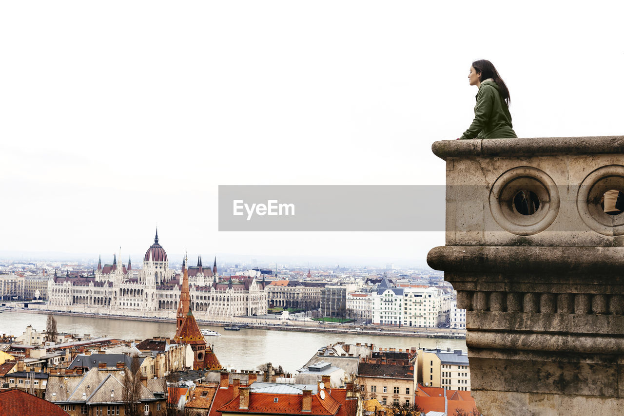 Hungary, budapest, woman looking on the parliament building from castle hill