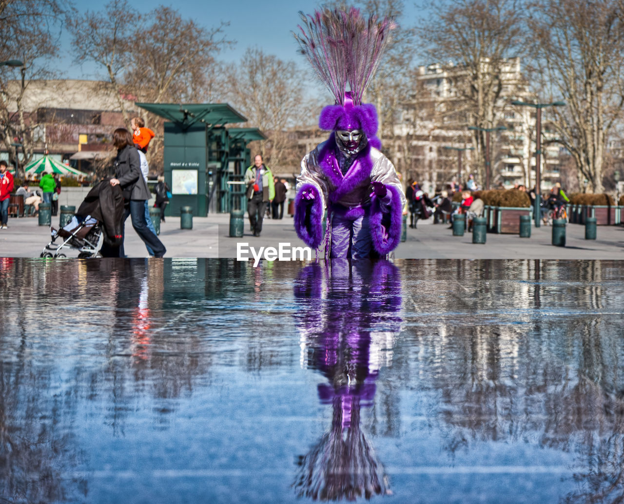 REFLECTION OF WOMAN IN WATER ON SIDEWALK