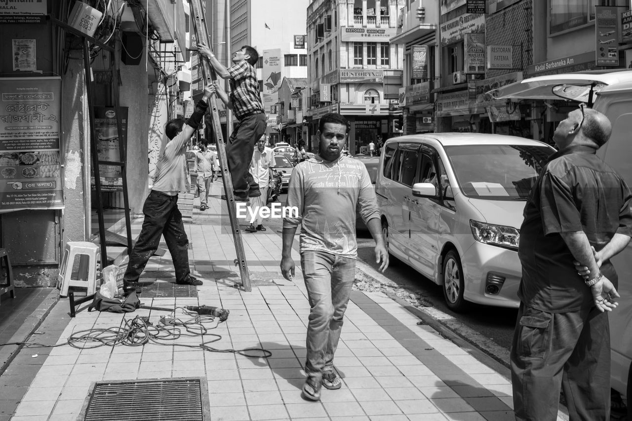 PEOPLE WALKING ON STREET IN CITY