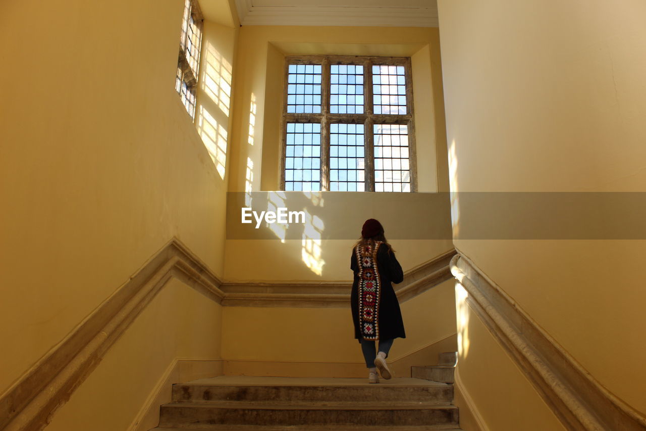 rear view of woman walking on staircase