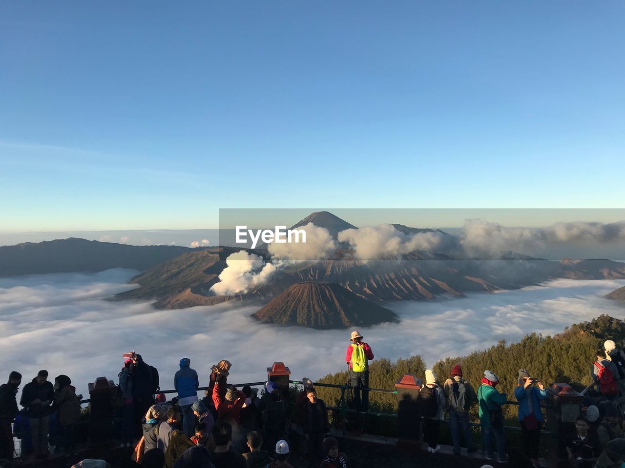 People looking at cloudscape against sky