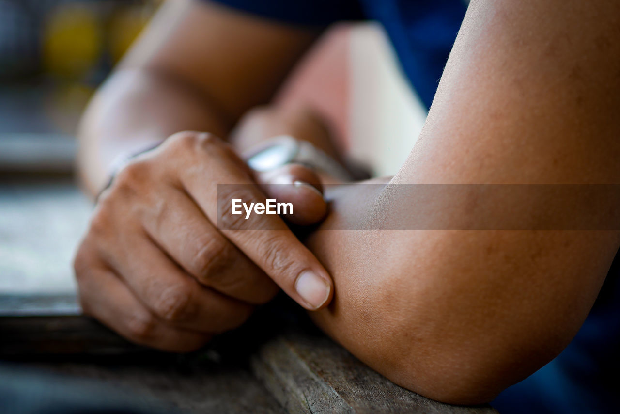 Close-up of man sitting on table