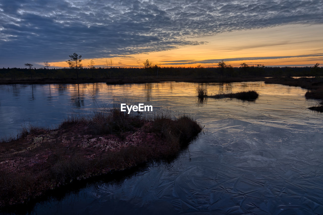 Scenic view of lake against sky at sunset