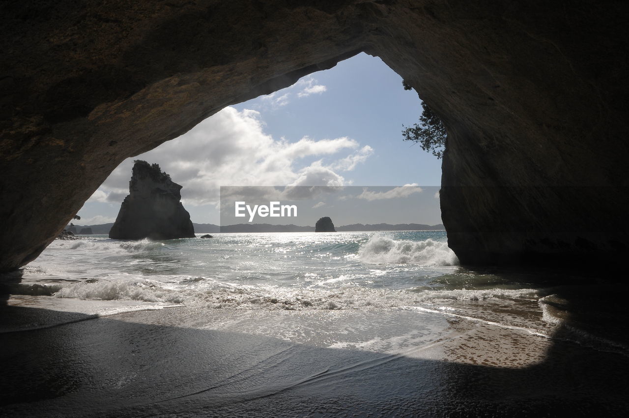 Sea seen through cave on sunny day