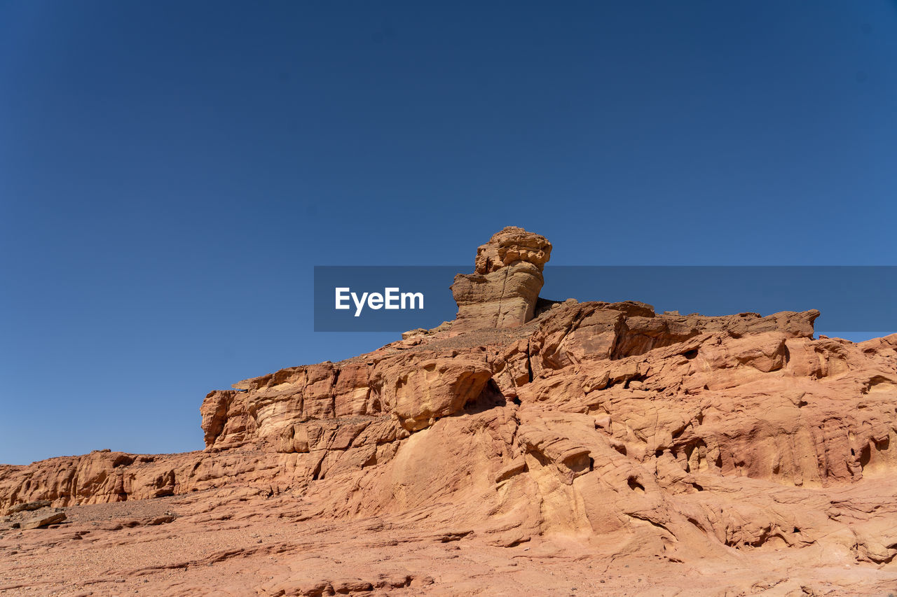 natural environment, rock, sky, nature, rock formation, scenics - nature, desert, landscape, clear sky, environment, land, blue, travel destinations, climate, beauty in nature, mountain, no people, valley, non-urban scene, wadi, travel, geology, arid climate, tranquility, arch, sunny, day, outdoors, plateau, formation, tranquil scene, semi-arid, remote, sunlight, physical geography, copy space, extreme terrain, terrain, sand, eroded, dry