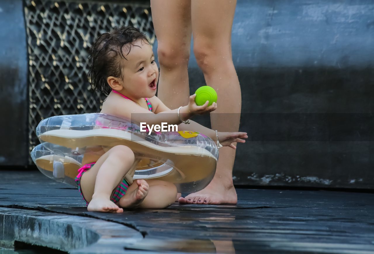 LOW SECTION OF GIRL PLAYING WITH WATER