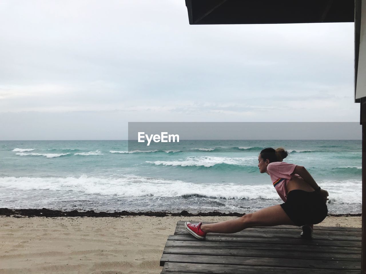 Woman stretching leg at beach