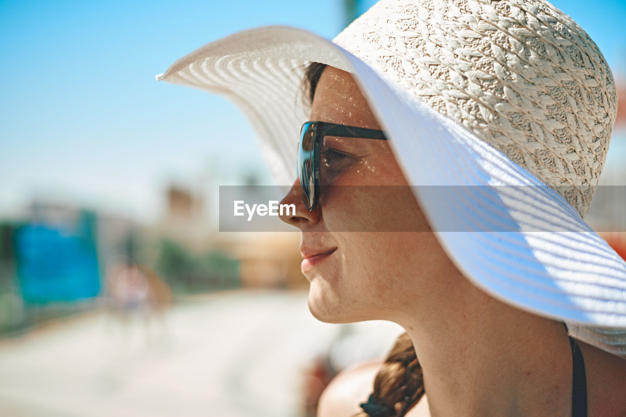 Close-up of woman wearing hat looking away outdoors