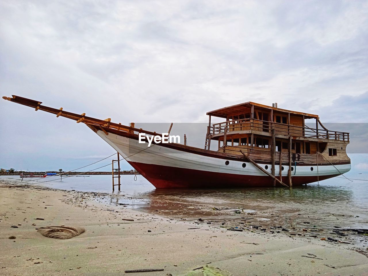 Ship moored on beach against sky