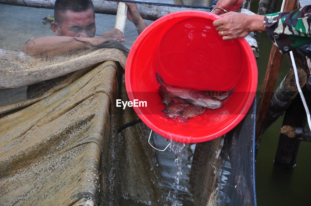 HIGH ANGLE VIEW OF PEOPLE HOLDING RED WATER