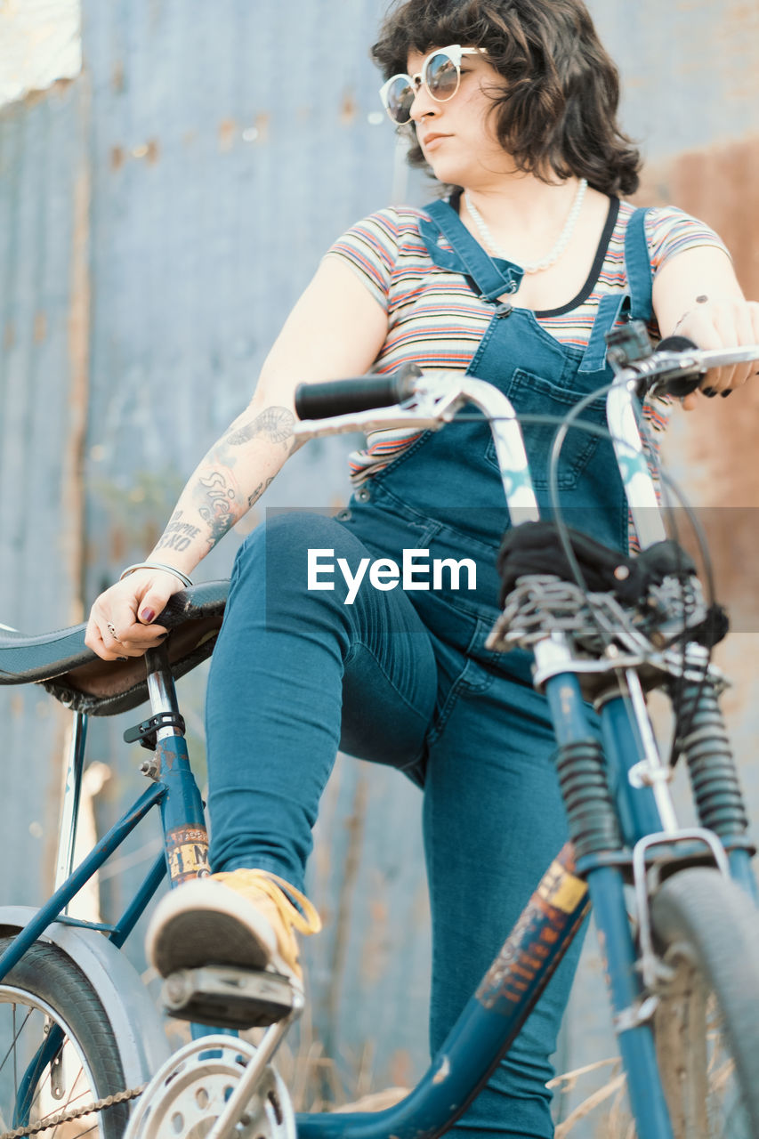 Low angle portrait of woman about to ride bicycle