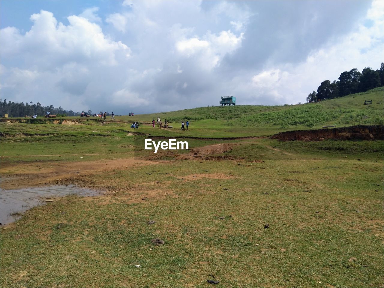 Scenic view of tourist land against dramatic sky with people walking .