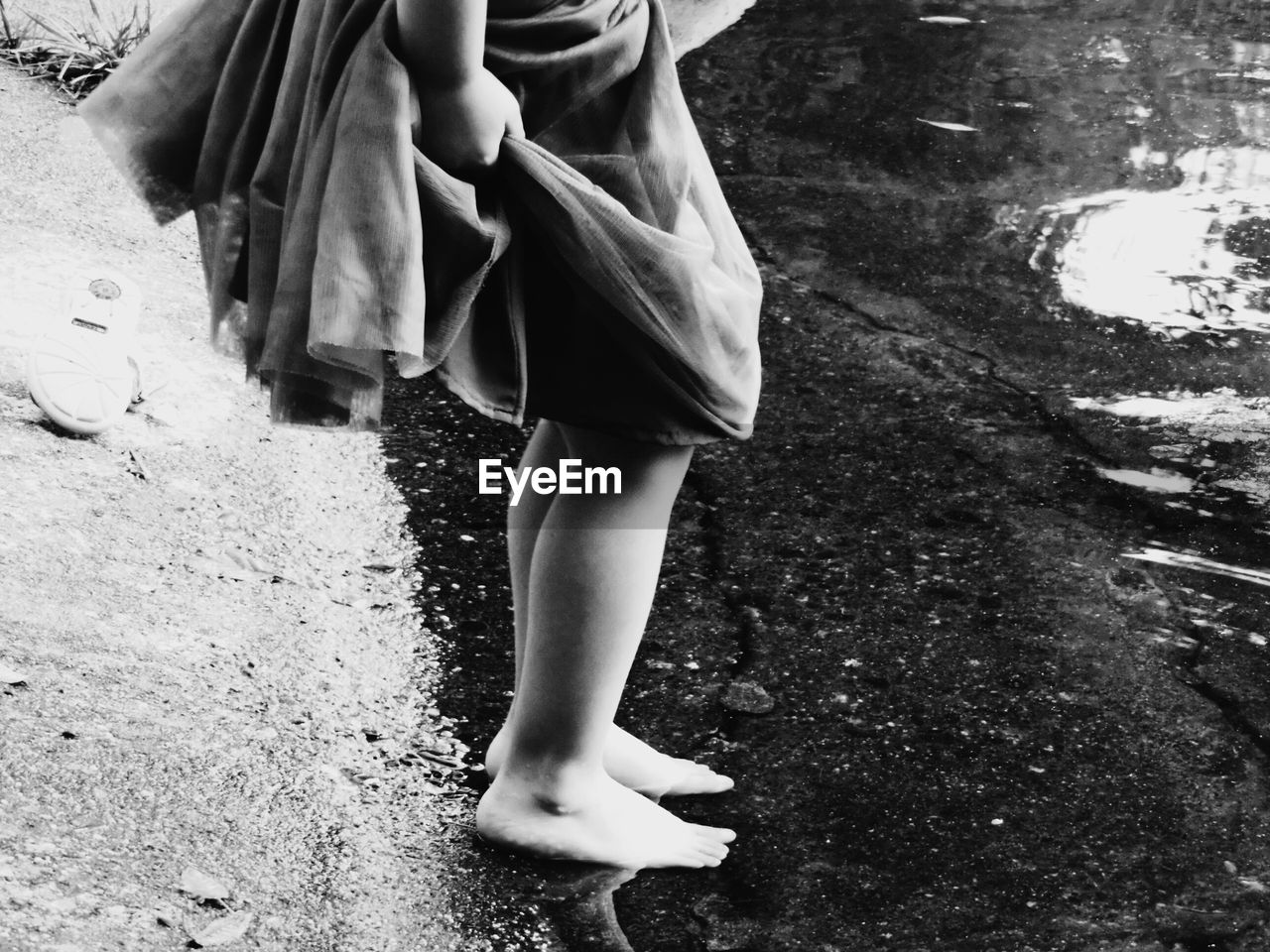 Low section of girl standing on lakeshore