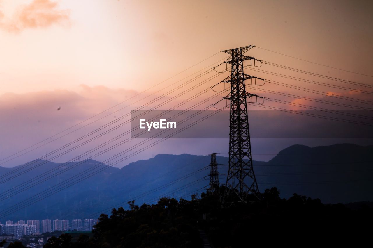 LOW ANGLE VIEW OF ELECTRICITY PYLON AGAINST SKY AT SUNSET