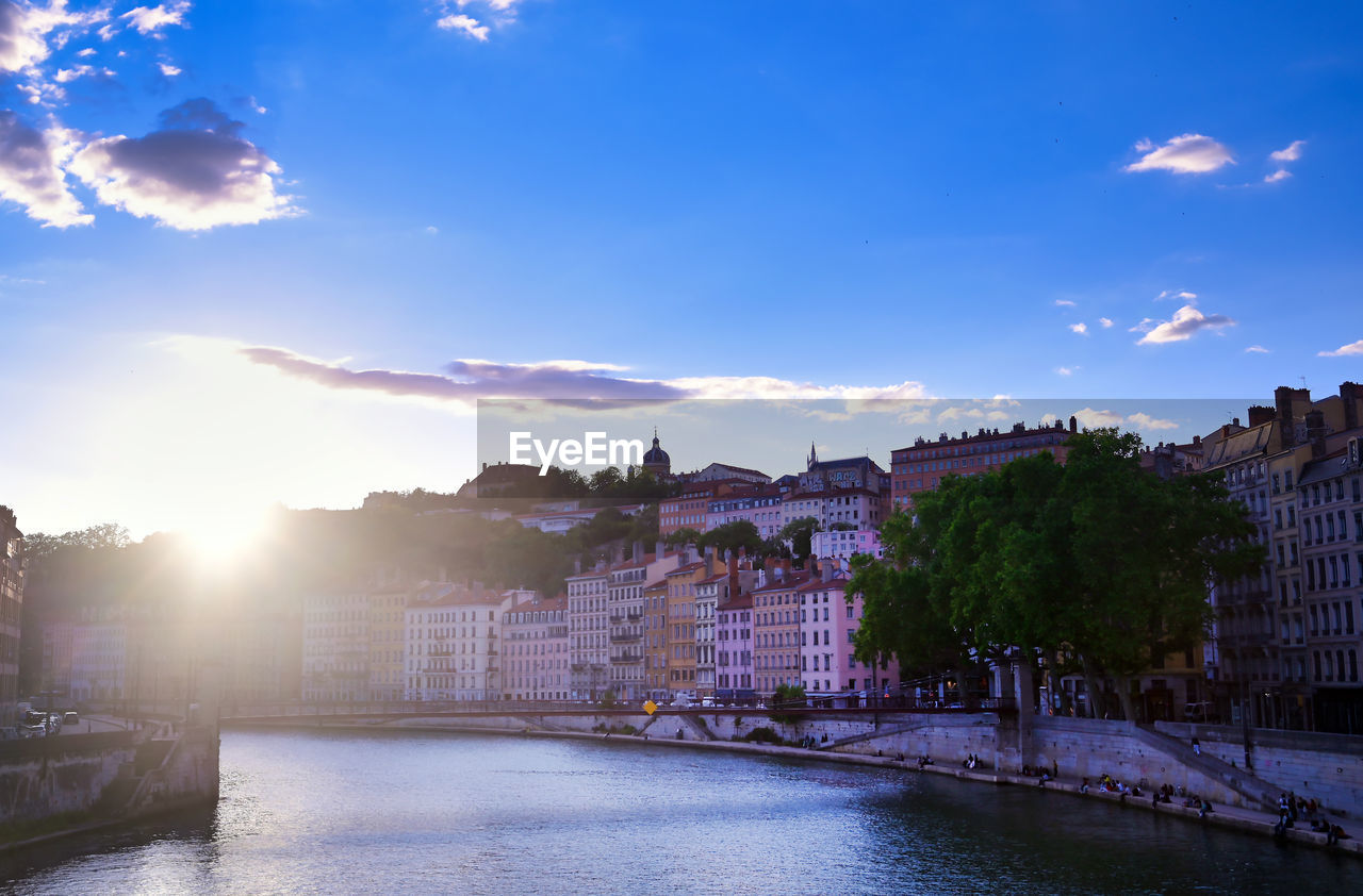 RIVER AMIDST BUILDINGS AGAINST SKY IN CITY