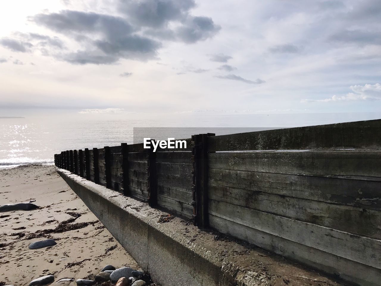 VIEW OF GROYNE ON BEACH AGAINST SKY