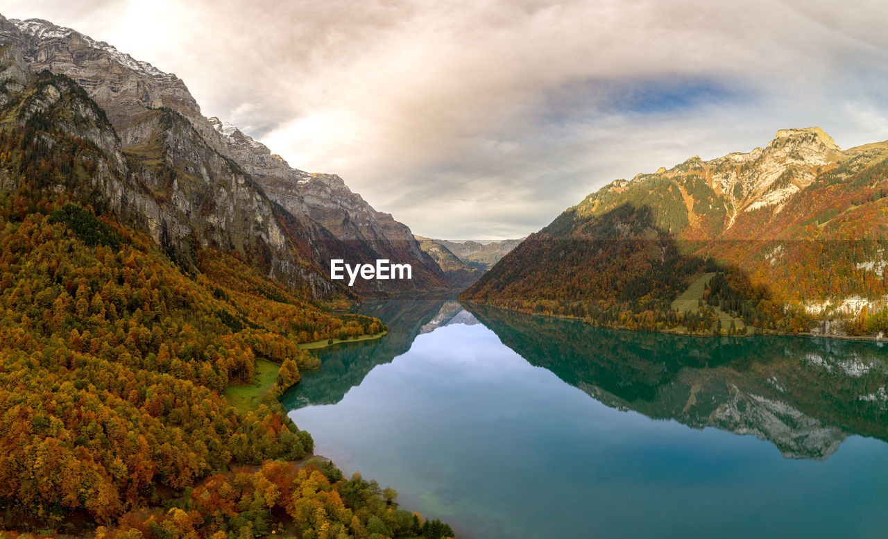 Scenic view of lake by mountains against sky