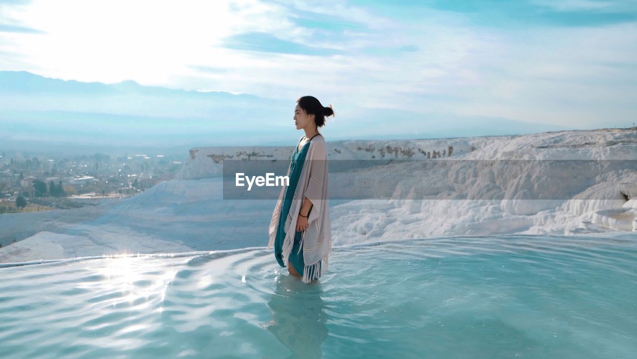 Young woman standing at travertine pools in pamukkale