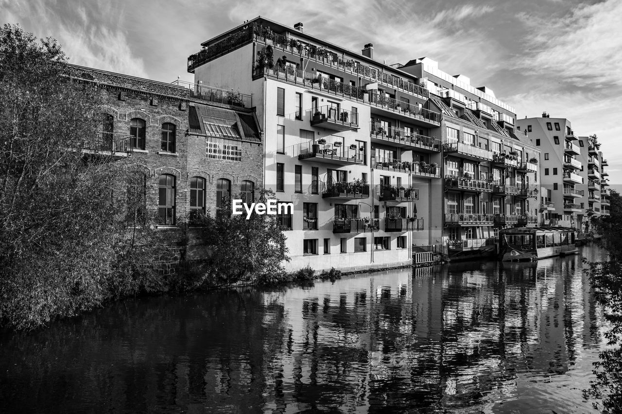 architecture, building exterior, built structure, black and white, water, cityscape, monochrome photography, sky, monochrome, waterway, building, reflection, house, nature, urban area, city, cloud, tree, no people, residential district, canal, waterfront, travel destinations, outdoors, day, plant