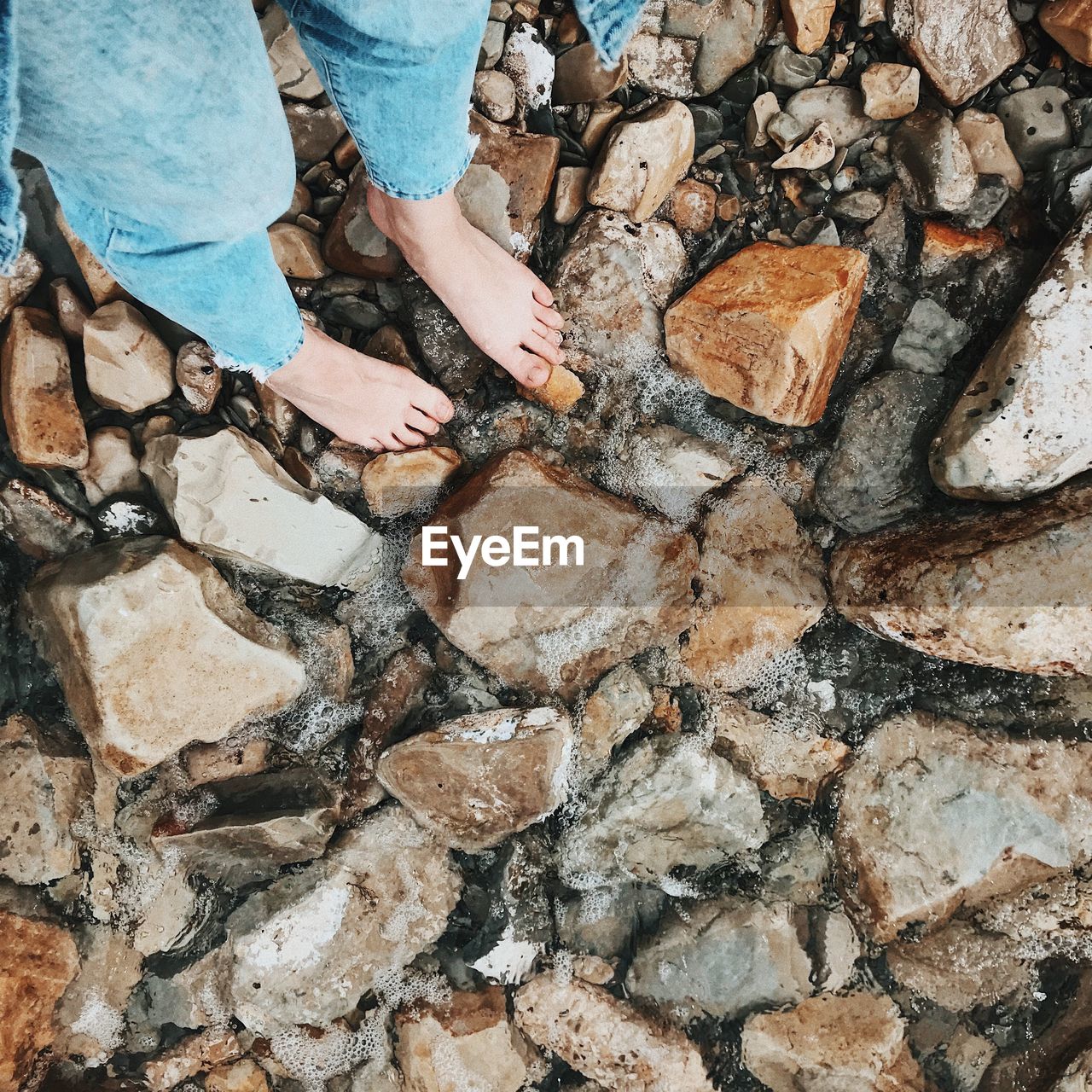 Low section of person standing on rock