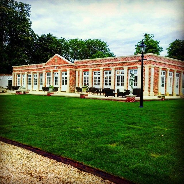 VIEW OF BUILDING WITH LAWN IN BACKGROUND