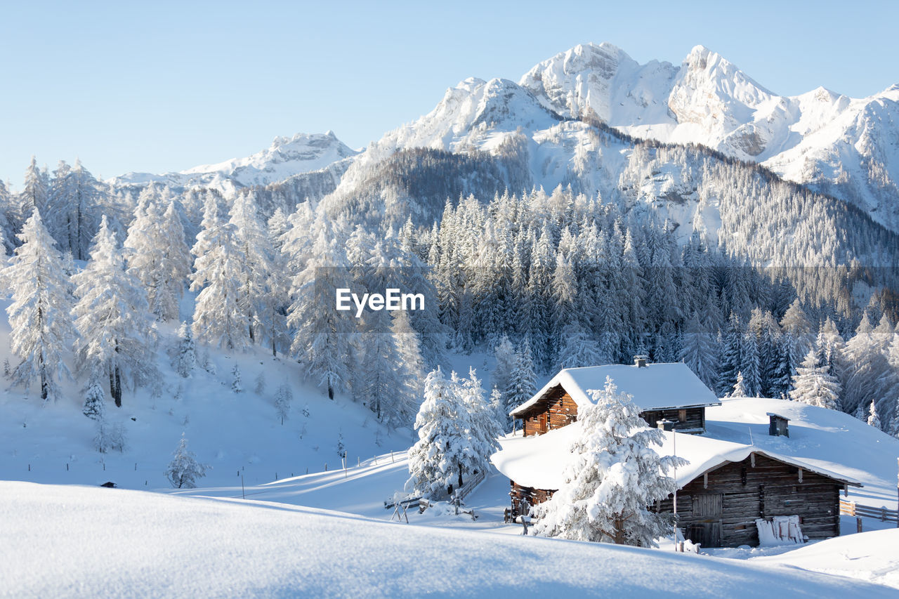 Beautiful winter scenery. austrian countryside with a snowcapped wooden hut