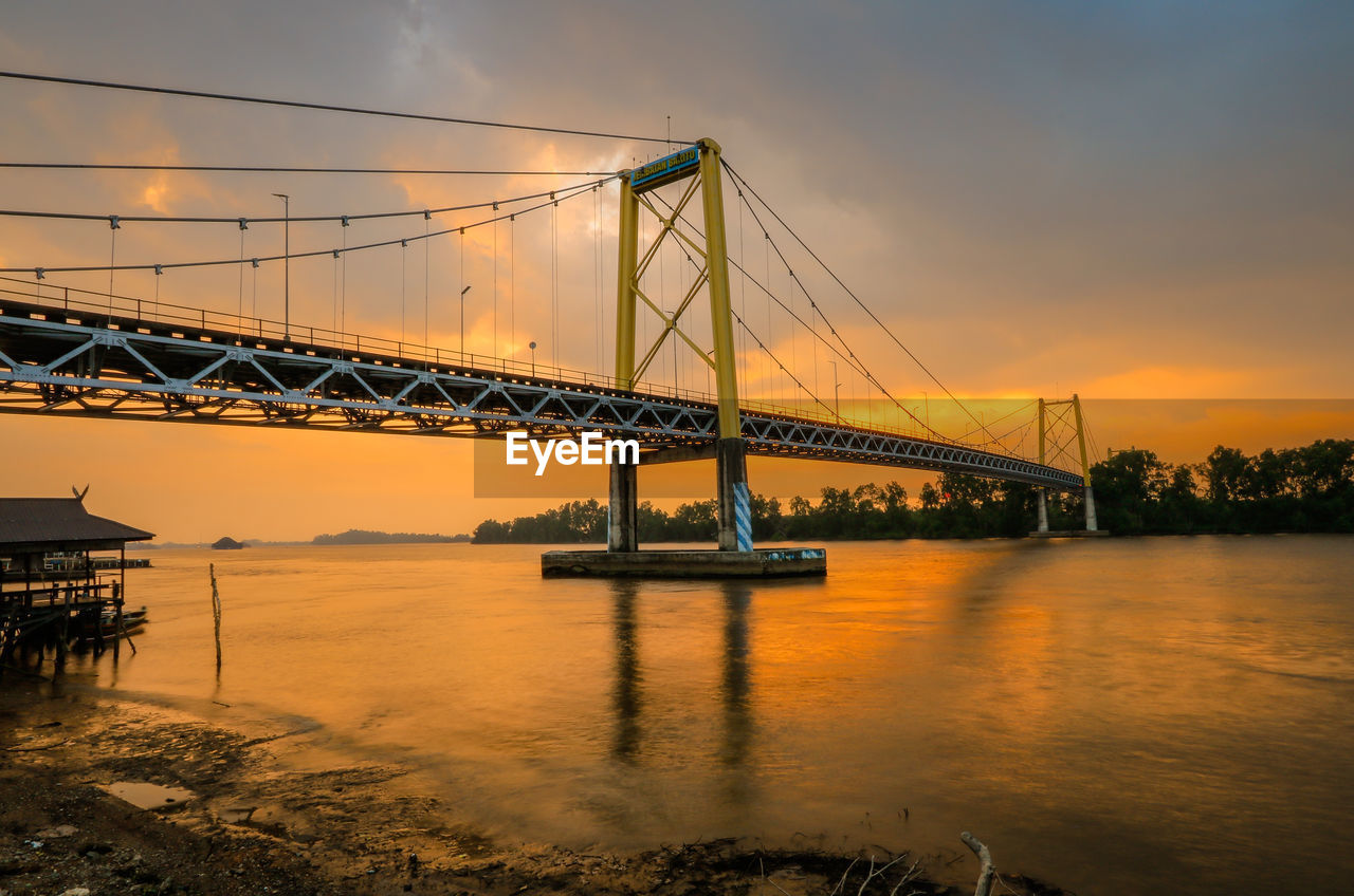 Bridge over river during sunset