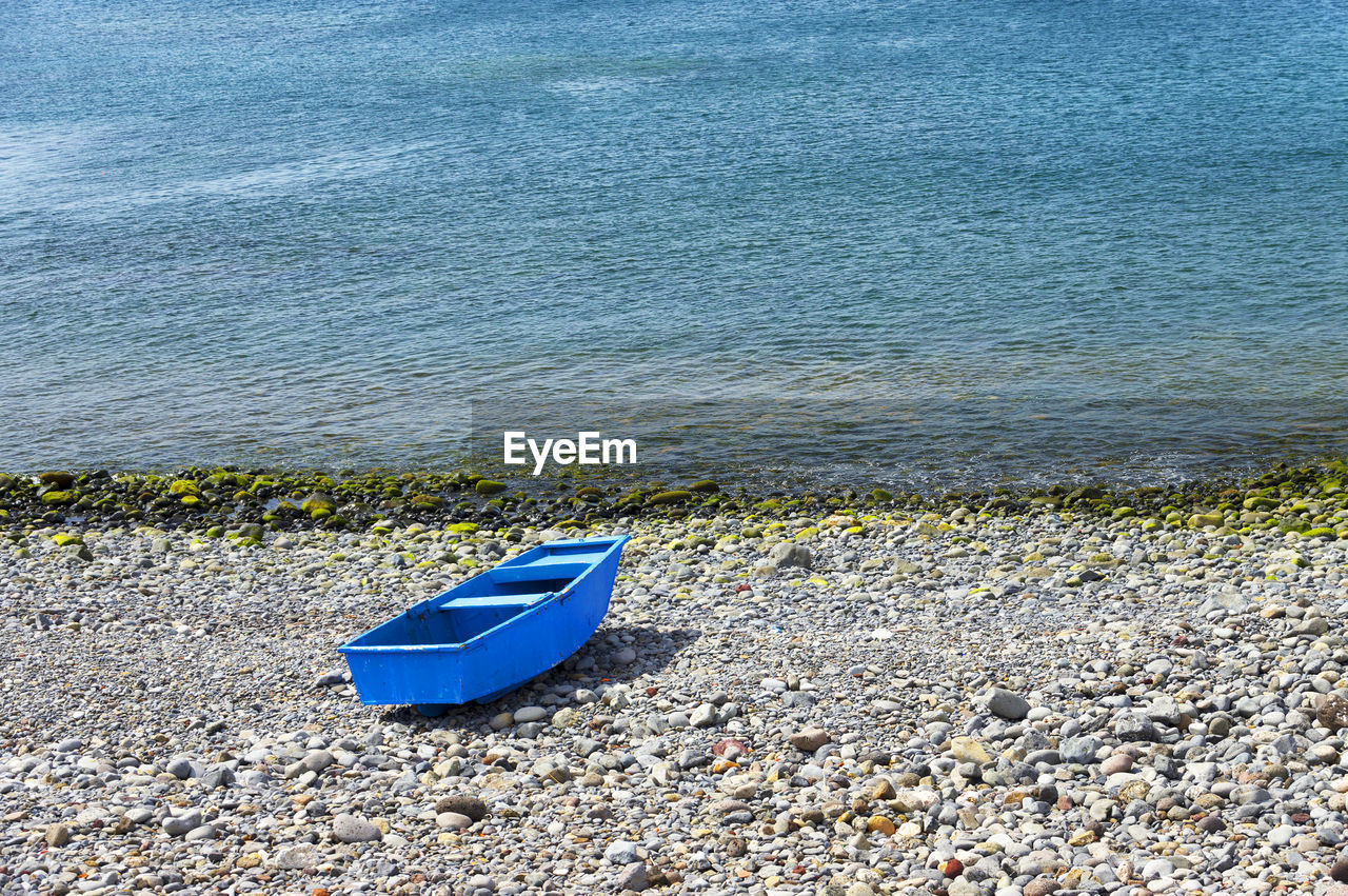 High angle view of blue on boat on pebbles at shore