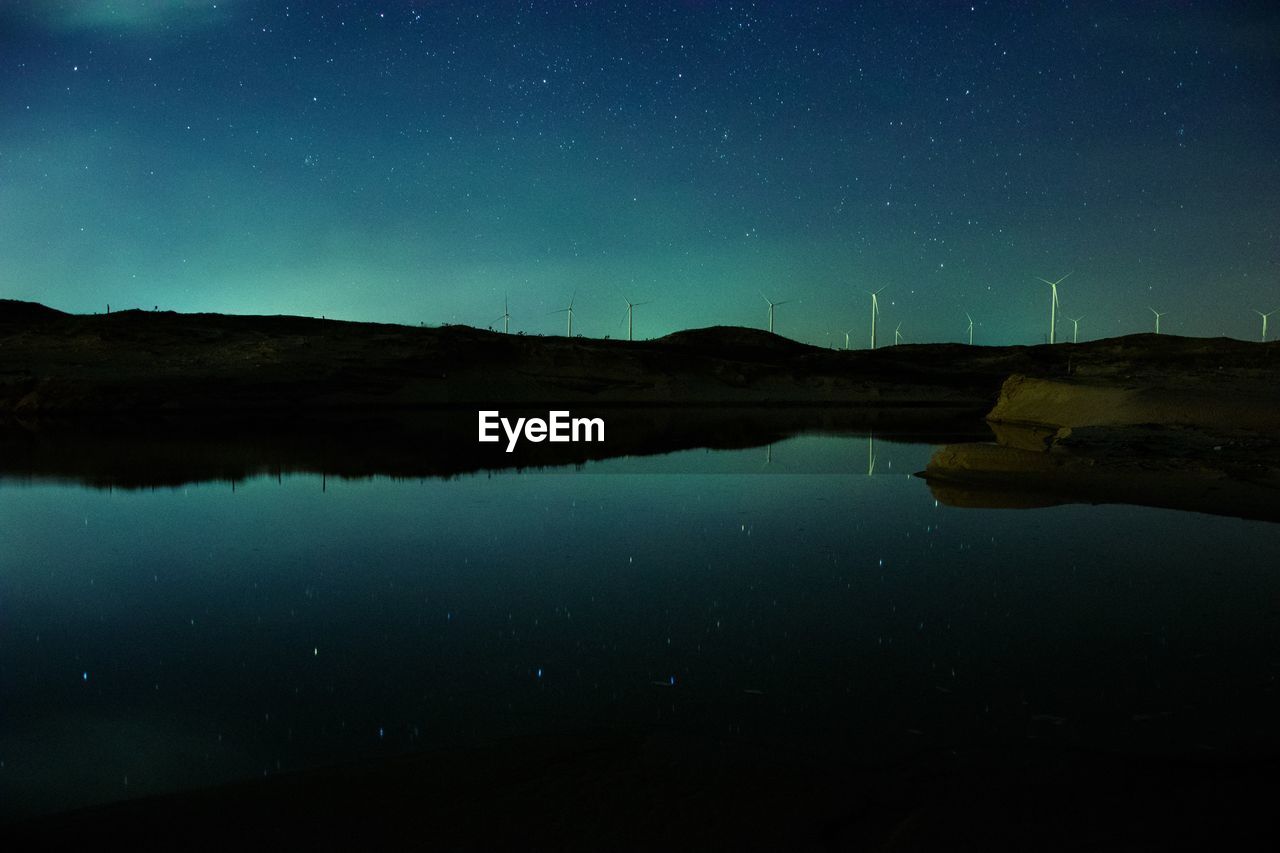 Scenic view of lake against sky at night