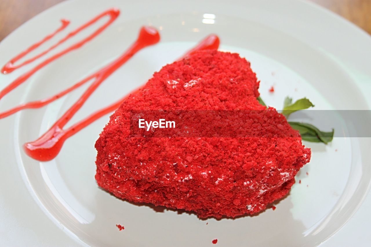 CLOSE-UP OF ICE CREAM IN PLATE WITH RED CAKE