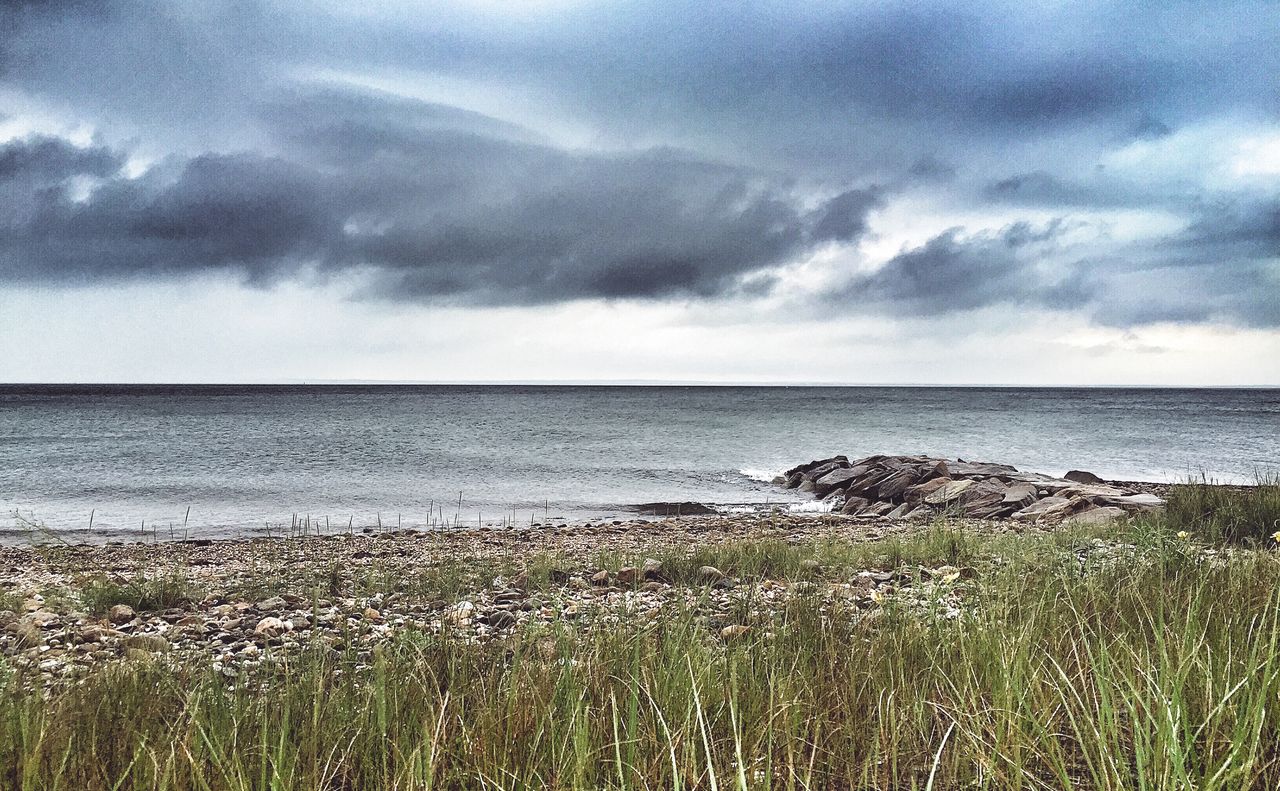 SCENIC VIEW OF SEA AND MOUNTAIN AGAINST CLOUDY SKY