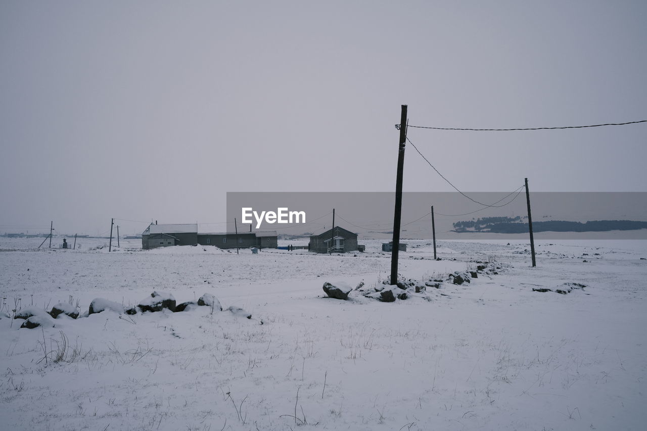 Scenic view of snow covered field against clear sky