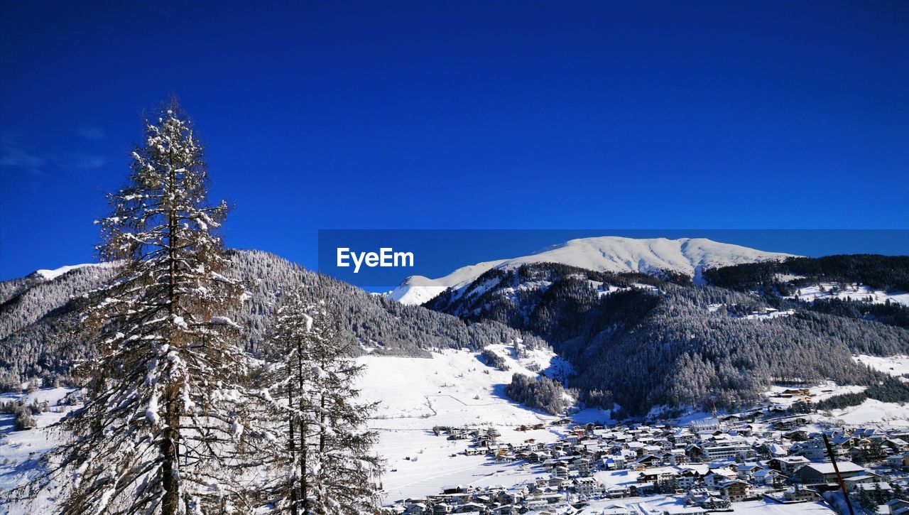 Scenic view of snowcapped mountains against clear blue sky