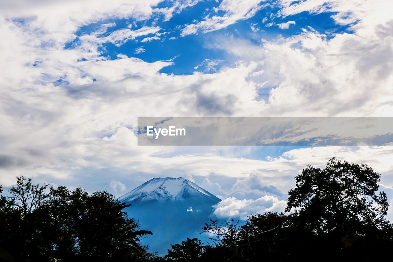 LOW ANGLE VIEW OF MOUNTAIN RANGE AGAINST CLOUDY SKY