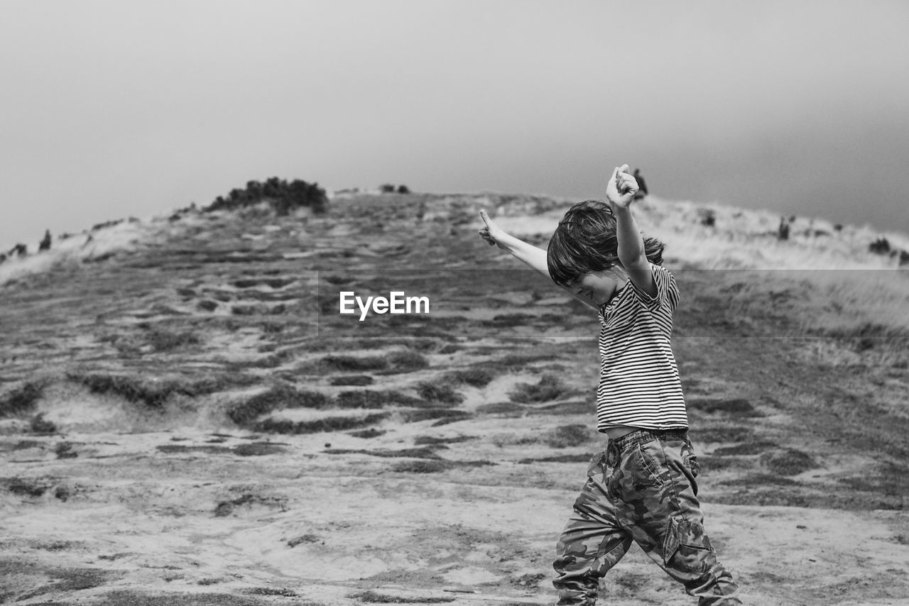 Side view of boy walking on mountain