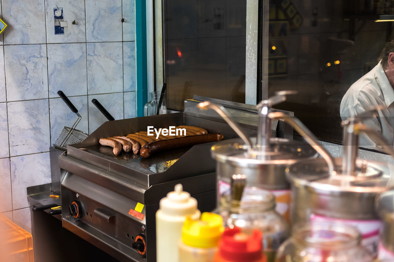 Sausages being grilled on barbecue in commercial kitchen