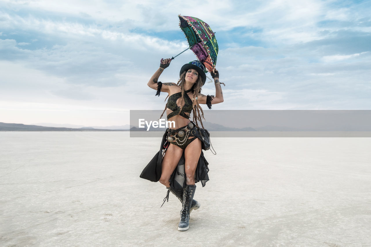 WOMAN WITH UMBRELLA STANDING ON THE LAND