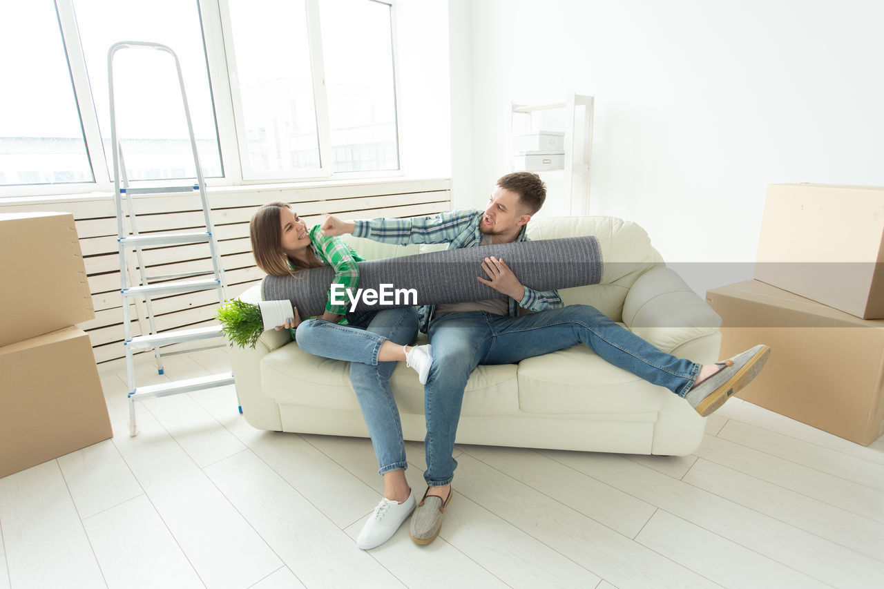 PEOPLE SITTING ON FLOOR AT HOME